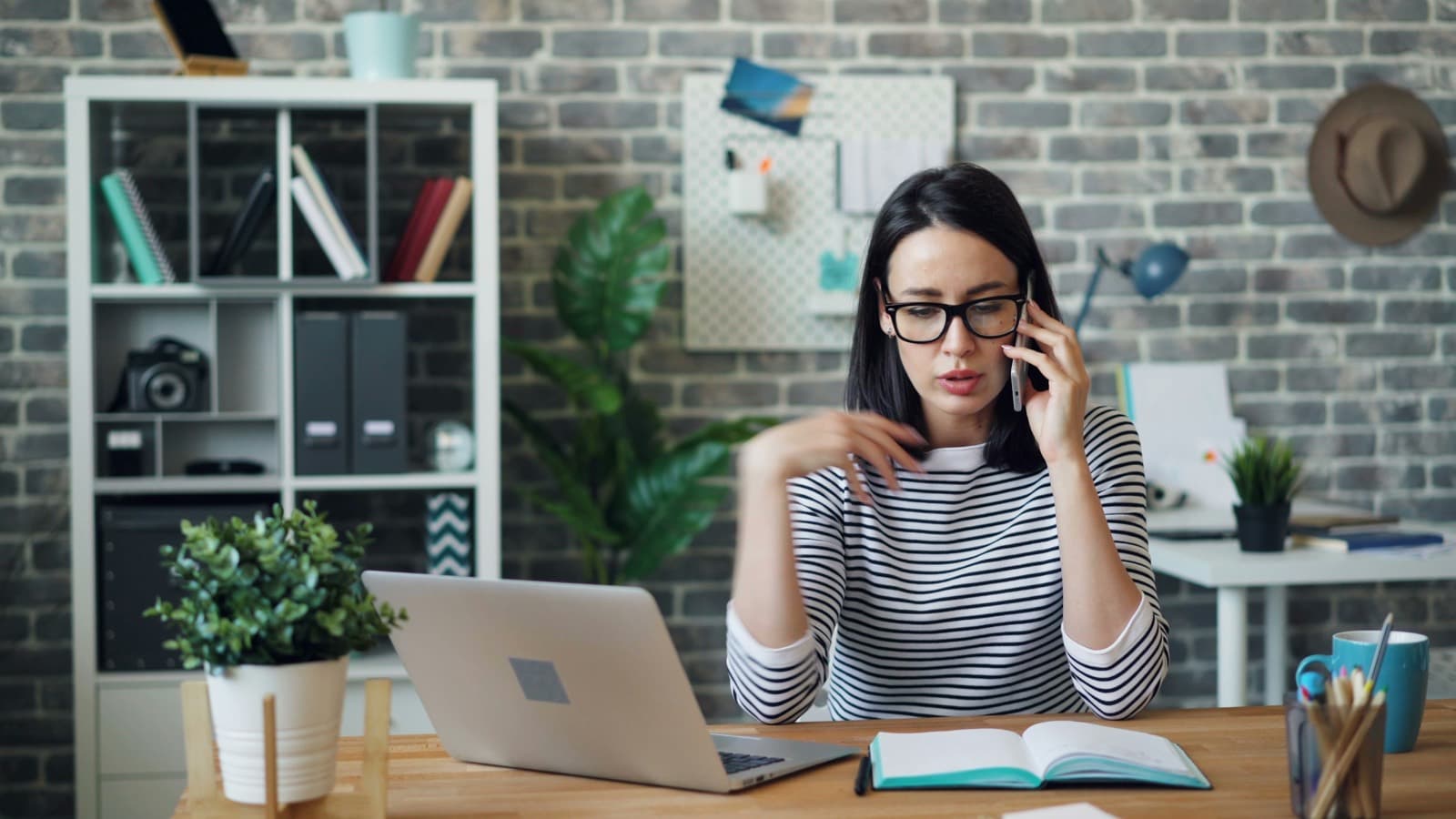 Mitarbeiterin am Schreibtisch im Gespräch am Telefon